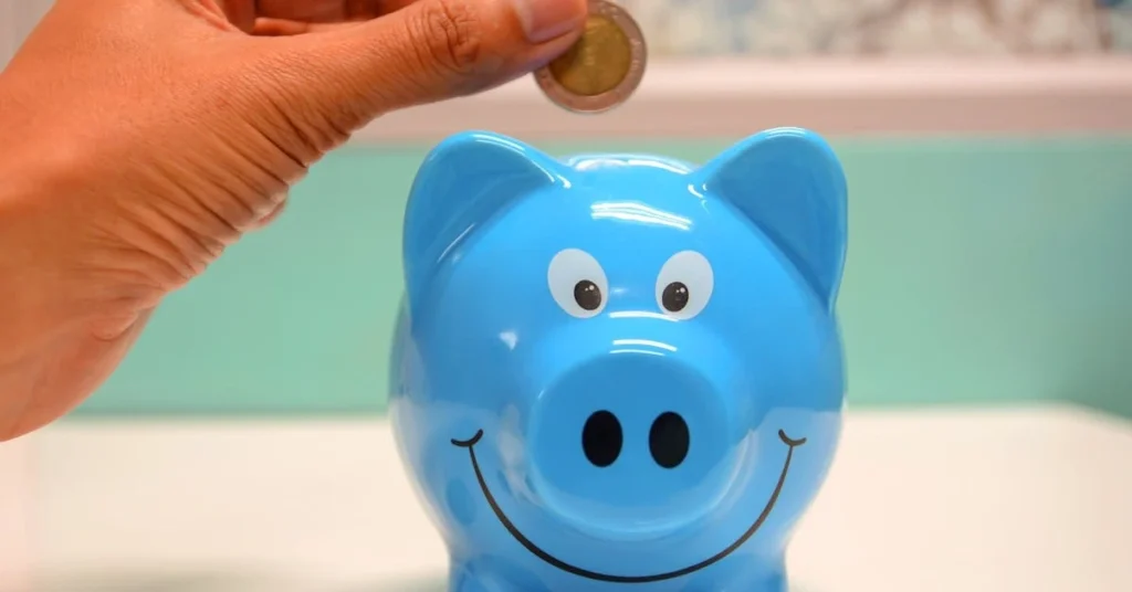A hand dropping some change into a piggy bank pot