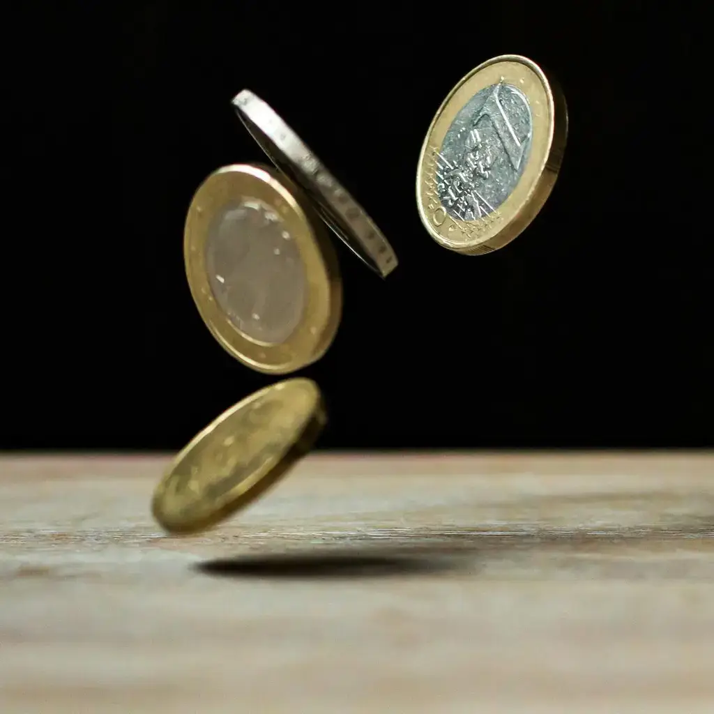Pound coins falling onto a table