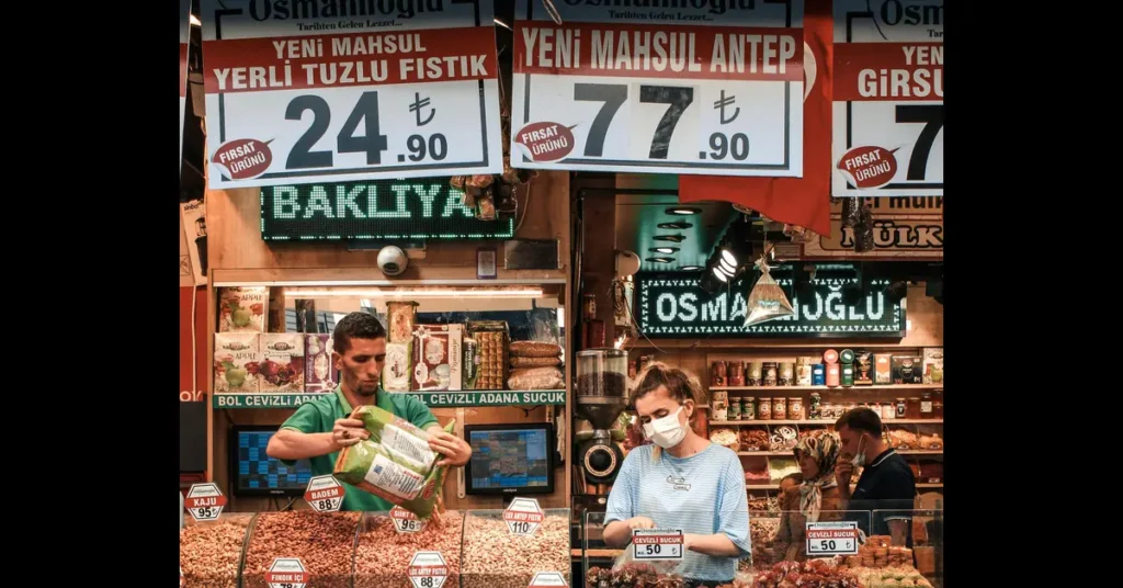 Two people stood in a shop stall with price signs around